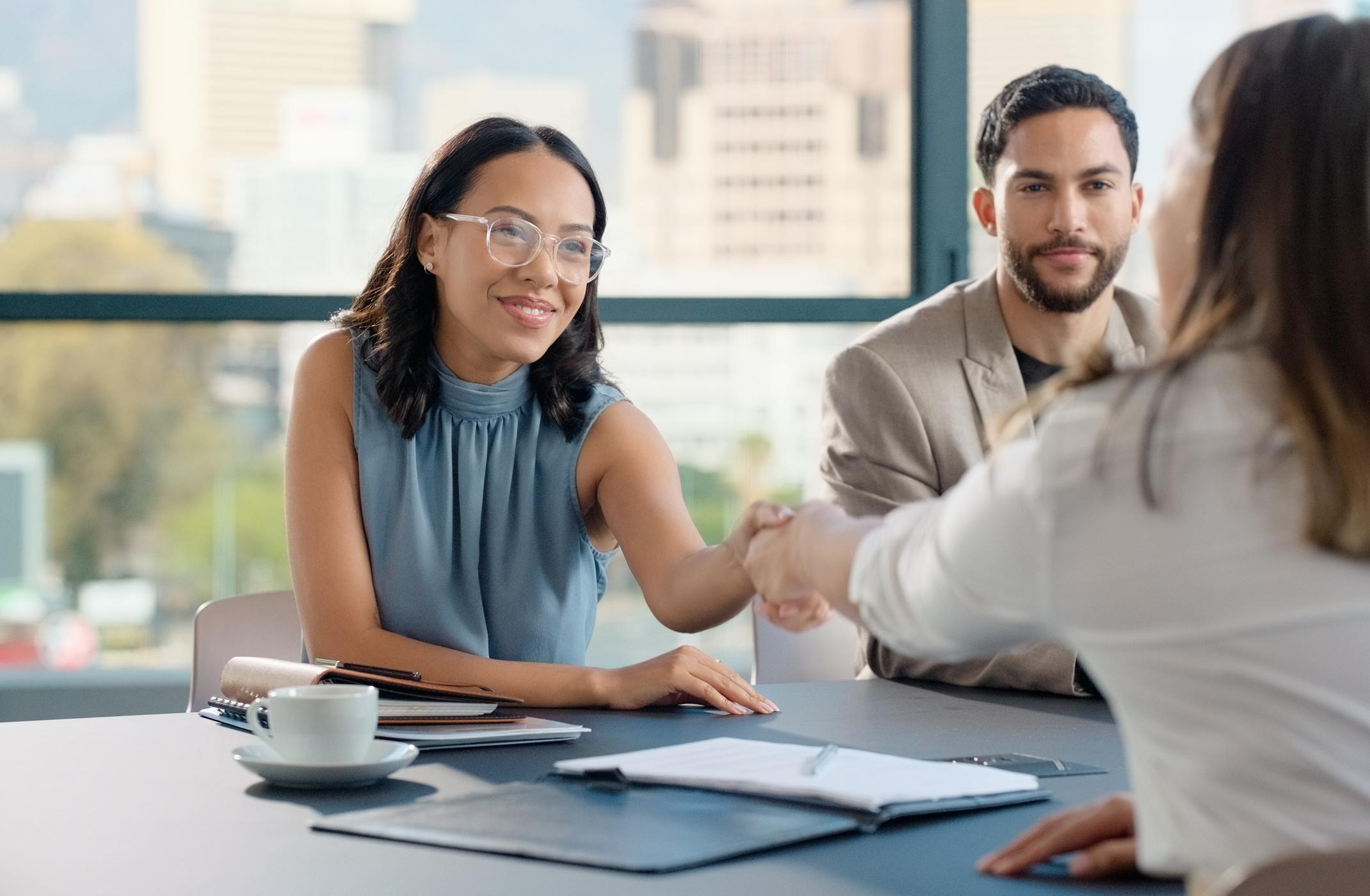 woman shaking hands with another woman